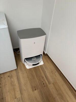 a small white refrigerator next to a small white washing machine
