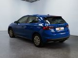 the rear of a blue car is parked in a white room