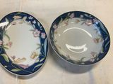 two blue and white plates with floral designs on them on a table