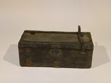 a small metal box with a handle on a white surface