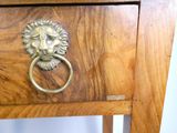 une table en bois dotée d'un tiroir orné d'une tête de lion