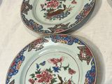 three plates with floral designs on them sit on a table