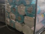 de nombreux rouleaux de papier toilette posés sur un chariot dans un entrepôt