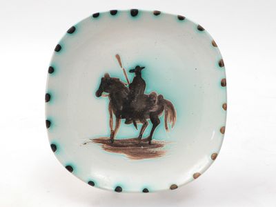 a plate with a picture of a man riding a horse