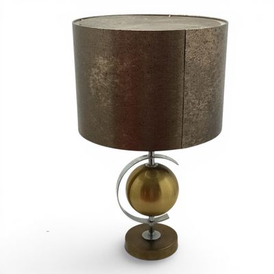 a close up of a lamp on a table with a brown shade