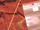un sac en plastique auquel est attachée une chaîne, posé sur un lit