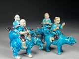 three figurines of people riding on horses with a dog