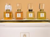 four bottles of perfume sitting on top of a white box