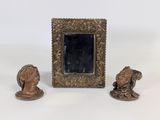 une photo représentant un cadre et deux figurines posées sur une table