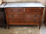 a marble top dresser in a corner of a room