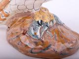 a figurine of a bird sitting on top of a shell