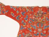 a red jacket with a dragon on it on a white surface