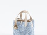 un petit sac bleu et blanc avec des anses en cuir, sur fond blanc