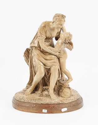 a statue of a woman holding a child on top of a wooden base