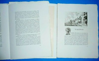 an open book on a blue surface with a drawing of a street