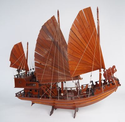 une maquette en bois d'un bateau aux voiles rouges