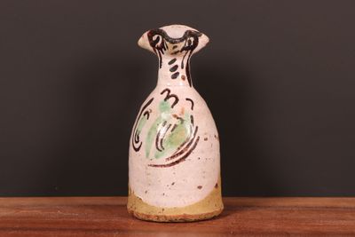 un vase blanc orné d'un motif vert et noir