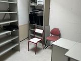 une pièce contenant un bureau, des étagères et une chaise