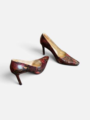 une paire d'escarpins rouges en peau de serpent à bout pointu