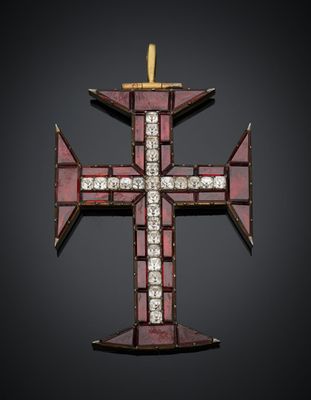 un pendentif en forme de croix rouge et or, orné de diamants, sur fond noir