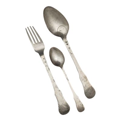deux cuillères en argent et une fourchette sur fond blanc
