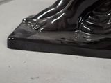 a statue of a woman sitting on top of a black base