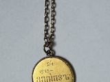 a gold coin that is on a chain on a table