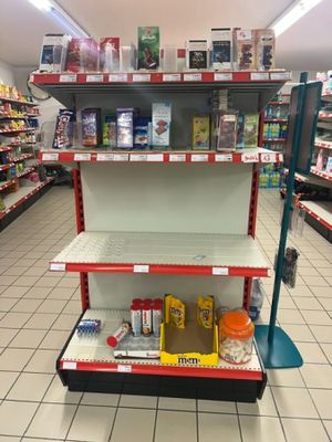 une étagère au milieu d'un magasin, sur laquelle sont disposés des articles