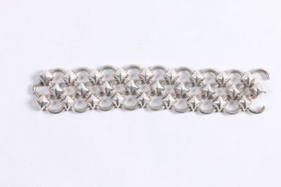 gros plan d'un bracelet en chaîne en argent sur une surface blanche