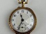 a gold pocket watch with a white face on a white surface