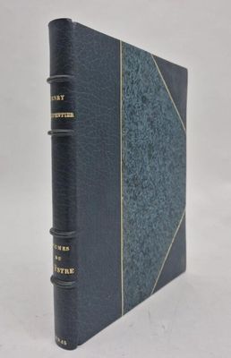 un livre bleu orné de lettres dorées, posé sur une surface blanche