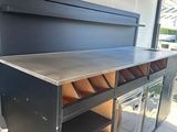 une cuisine d'extérieur avec un barbecue encastré dans le mur
