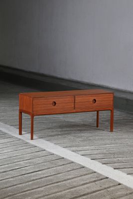 une petite table en bois surmontée de deux tiroirs