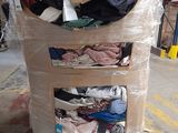 a cart with a lot of clothes on it in a warehouse