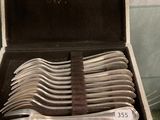 de nombreuses cuillères en argent dans une boîte posée sur une table