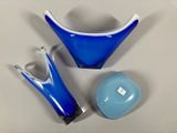 three pieces of blue and white glass on a table