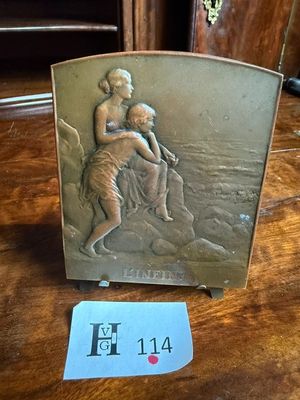 une plaque représentant une femme tenant un enfant dans ses bras, posée sur une table