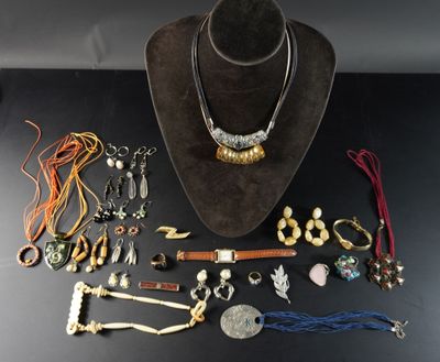 une table noire sur laquelle sont posés un chapeau marron et de nombreux bijoux