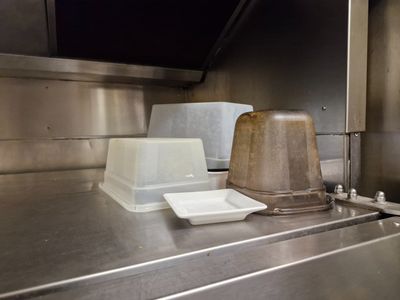 stainless steel counter top in a commercial kitchen with a plastic container on top of it