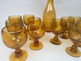 yellow glass goblets and vases are lined up on a white surface