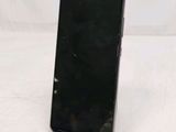 the back of a black cell phone sitting on top of a white surface
