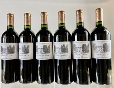 six bottles of wine are lined up in a row on a table