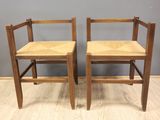 two wooden chairs sitting on top of a hard wood floor