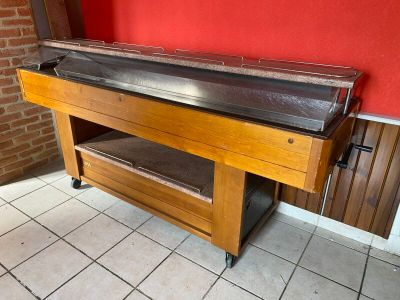 une table en bois sur laquelle est posée une casserole en métal