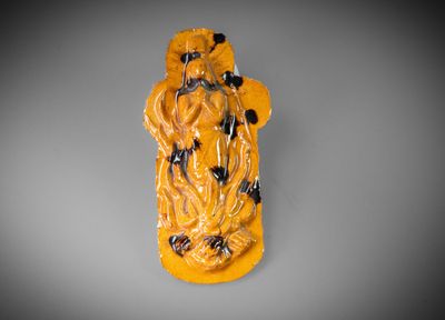 a yellow and black figurine of a man holding a flower