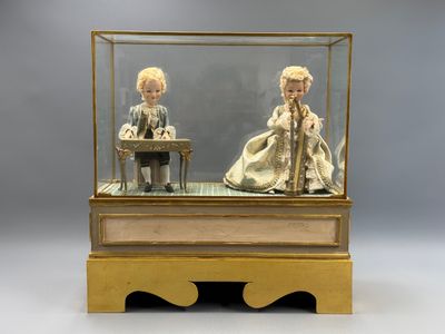 deux poupées dans une vitrine posée sur une table
