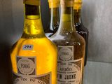 three bottles of liquor sit on a glass shelf in front of a mirror