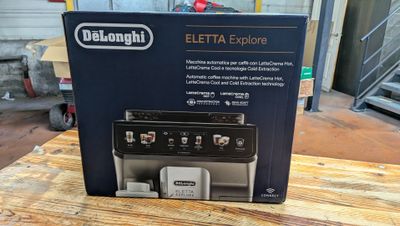 Le carton du nouveau Delonghi Eletta Explorer est posé sur la table.