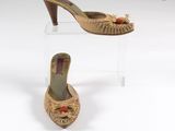 Deux paires de chaussures sont exposées sur un présentoir transparent