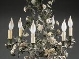 an image of a chandelier with flowers and candles hanging from it